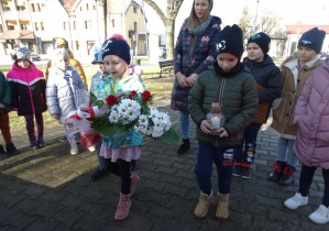 Dzieci składają kwiaty pod pomnikiem Niepodległości w Kleszczowie